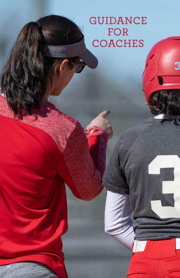 RED-S Guide for Coaches Softball coach in red talking to player